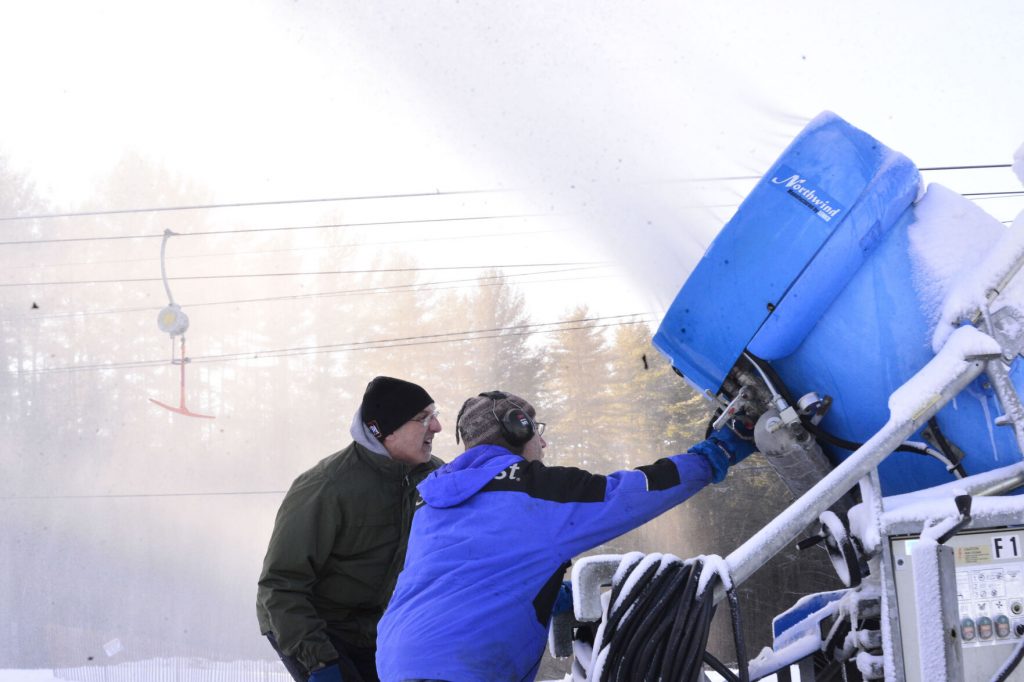 Ray Blow goes over the snow gun with John Crandall as they make snow at Living Memorial Park, in Brattleboro, in December 2021, to prepare for the ski hill to open on New Year's Eve.