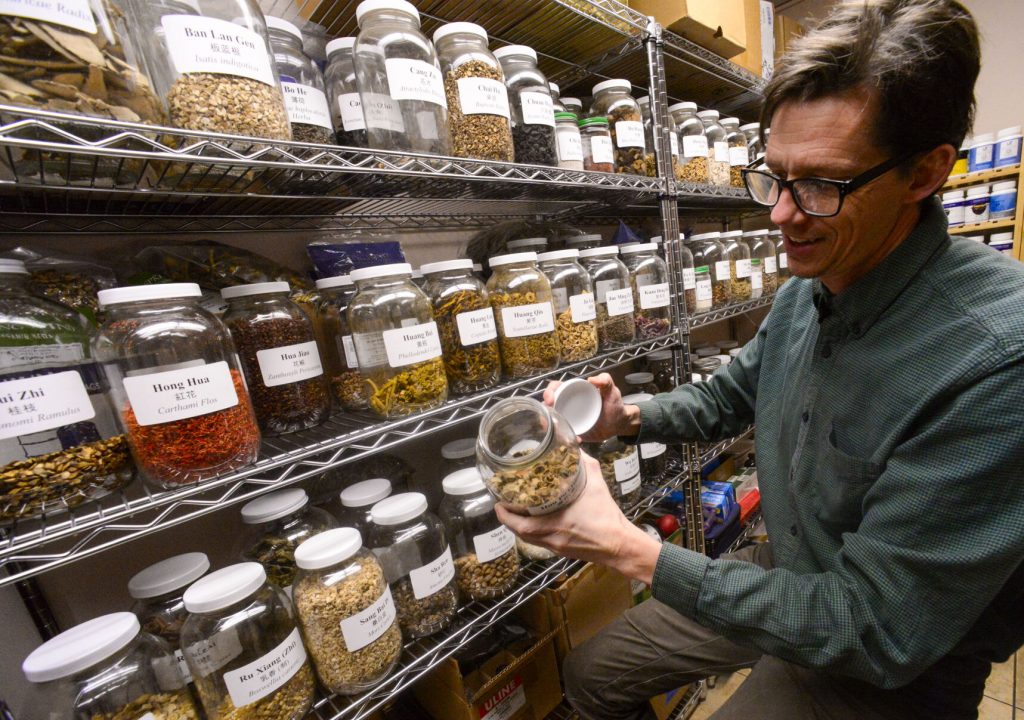 Stefan Grace, a licensed acupuncturist and owner of Confluence Acupuncture in Brattleboro, shows some of the herbs in his office. Kristopher Radder — Vermont Country. 